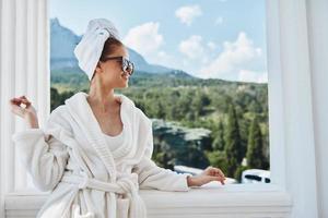 retrato mujer en un blanco túnica en el balcón poco en verde naturaleza inalterado foto