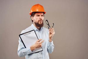 A man in orange paint with documents in hands building an industrial business photo