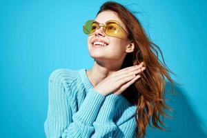 portrait of a woman in fashionable glasses blue background photo