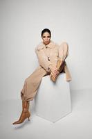 fashionable woman in coat sitting in brown boots fashion autumn style photo