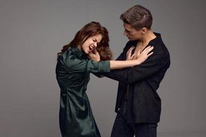 Aggressive woman and strict man on a gray background of conflict misunderstanding photo