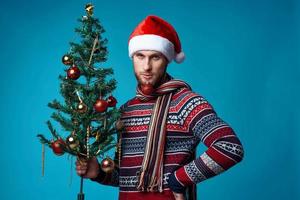 Cheerful man with a tree in his hands ornaments holiday fun red background photo