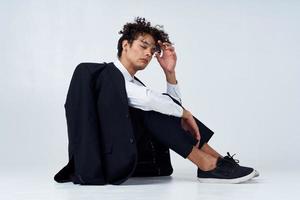 curly haired man in classic suit model studio photography sneakers photo