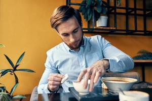 man eating lunch at cafe table break at work and interior photo