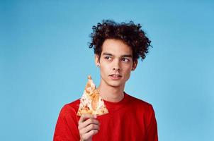 chico dónde es él y pelo en un rojo camiseta con un rebanada de Pizza en un azul antecedentes foto