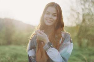 Portrait of a woman with a beautiful smile and straight teeth on a summer day in the sunset with flying curly hair photo