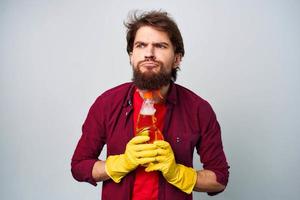 Man in yellow rubber gloves detergent housework rendering services close-up photo