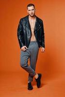 handsome man in leather jacket pumped up torso fashion studio isolated background photo