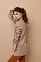 attractive woman in coat on beige background And hairstyle model photo