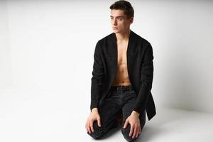 Handsome man black jacket kneeling luxury self confidence lifestyle photo