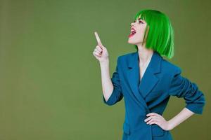 Portrait of a charming lady wearing a green wig blue jacket posing color background unaltered photo