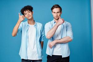 joven hombres en idéntico camisetas y azul camisas chateando amigos foto