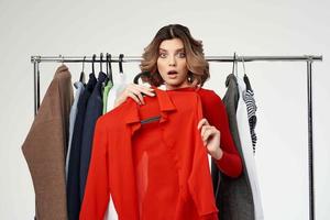 pretty woman in a red jacket near the wardrobe light background photo