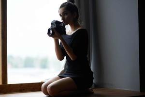 hermosa mujer participación un cámara cerca el ventana decoración Moda estilo de vida estudio foto