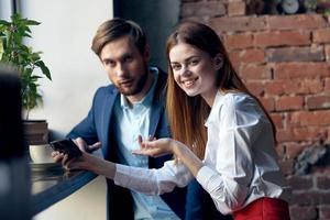 work colleagues man and woman sitting in a cafe with telephone communication photo
