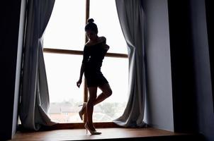 mujer silueta cerca ventana interior posando modelo foto