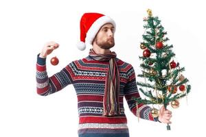 Cheerful man with a tree in his hands ornaments holiday fun studio posing photo