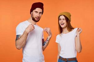 funny man and woman in t-shirts youth clothing orange background photo