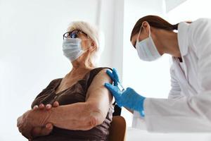 elderly woman with a doctor immunization safety drug injection photo