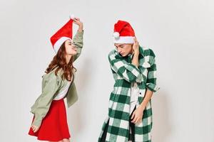 un hermosa mujer y un joven hombre en un festivo sombrero son teniendo divertido en un ligero antecedentes foto