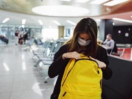 mujer mirando dentro un amarillo mochila comprobación cosas aeropuerto foto