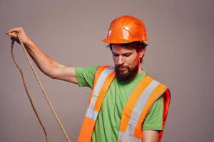 Man in construction uniform orange hard hat cropped view over beige background photo