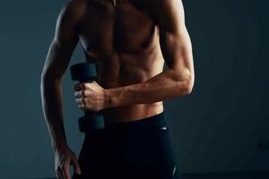 a man with a pumped up press workout with dumbbells exercises dark background photo