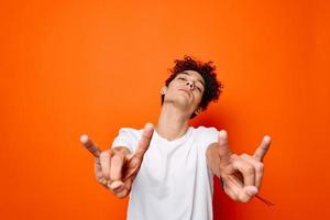 cute guy curly hair emotions grimace studio orange background photo