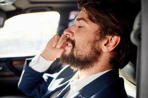 business man with a beard talking on the phone in a car trip photo