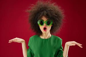 emotional woman gesturing with her hands afro hairstyle green glasses photo