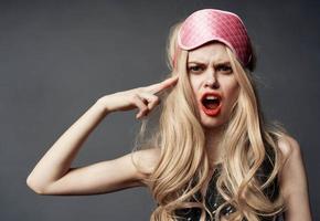 Blonde woman with pink mask for sleep alcoholism health problems model photo