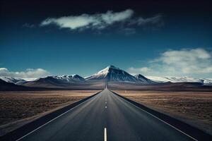 Empty asphalt road in Iceland with snow capped mountains in the background. photo