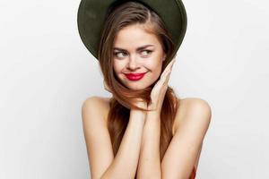 mujer en un verde sombrero sonrisa un Mira a el lado rojo labios foto