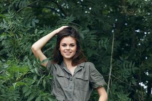 Woman outdoors touches the hair on her head and smiles nature photo