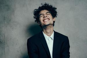 alegre hombre en un traje con Rizado pelo emociones de cerca oficial foto