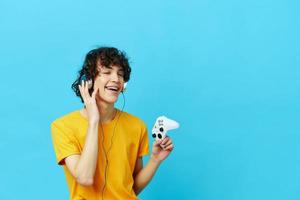 gamer yellow T-shirt with joystick video games blue background photo