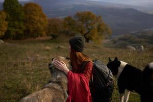 mujer con mochila en naturaleza siguiente a perro caminar amistad foto