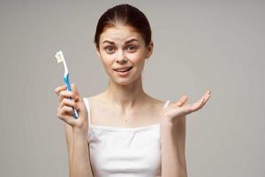 cheerful woman toothpaste brushing teeth dental health light background photo