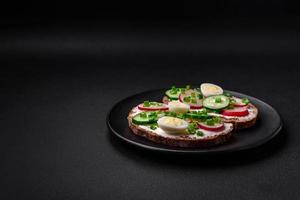 Delicious sandwich or bruschetta with cream cheese radish and green onions photo