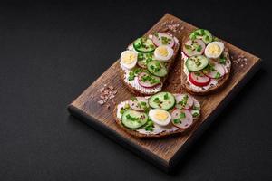 Delicious sandwich or bruschetta with cream cheese radish and green onions photo