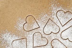 Making heart shaped cookies of spicy ginger dough for Valentines gift, backing background photo