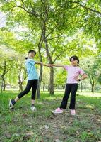 Two happy child girls with smiling in park outdoor. Children playing and enjoying summer day in the green park. photo