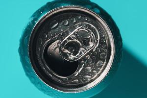 Cyan blue open soda can in shadow and light covered with water drops photo