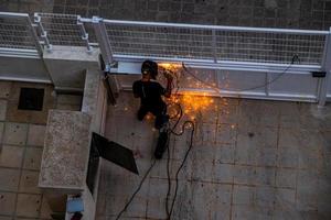 welder at work at a  metal gate top view photo