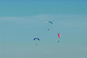 paragliders in the blue cloudless sky photo