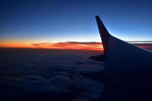 misterioso puesta de sol con nubes desde el avión ventana con foto