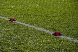 formación fútbol americano tono con artificial verde césped y formación SIDA iluminado por el tarde Dom foto