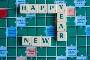 wishes for the new year arranged with letters on the game board in scrabble photo