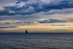 seaside landscape with clouds and sailboat on the horizon Alicante Spain photo