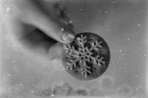 l tasty gingerbread with white snowflake decoration for Christmas kept in the hand of a chil photo